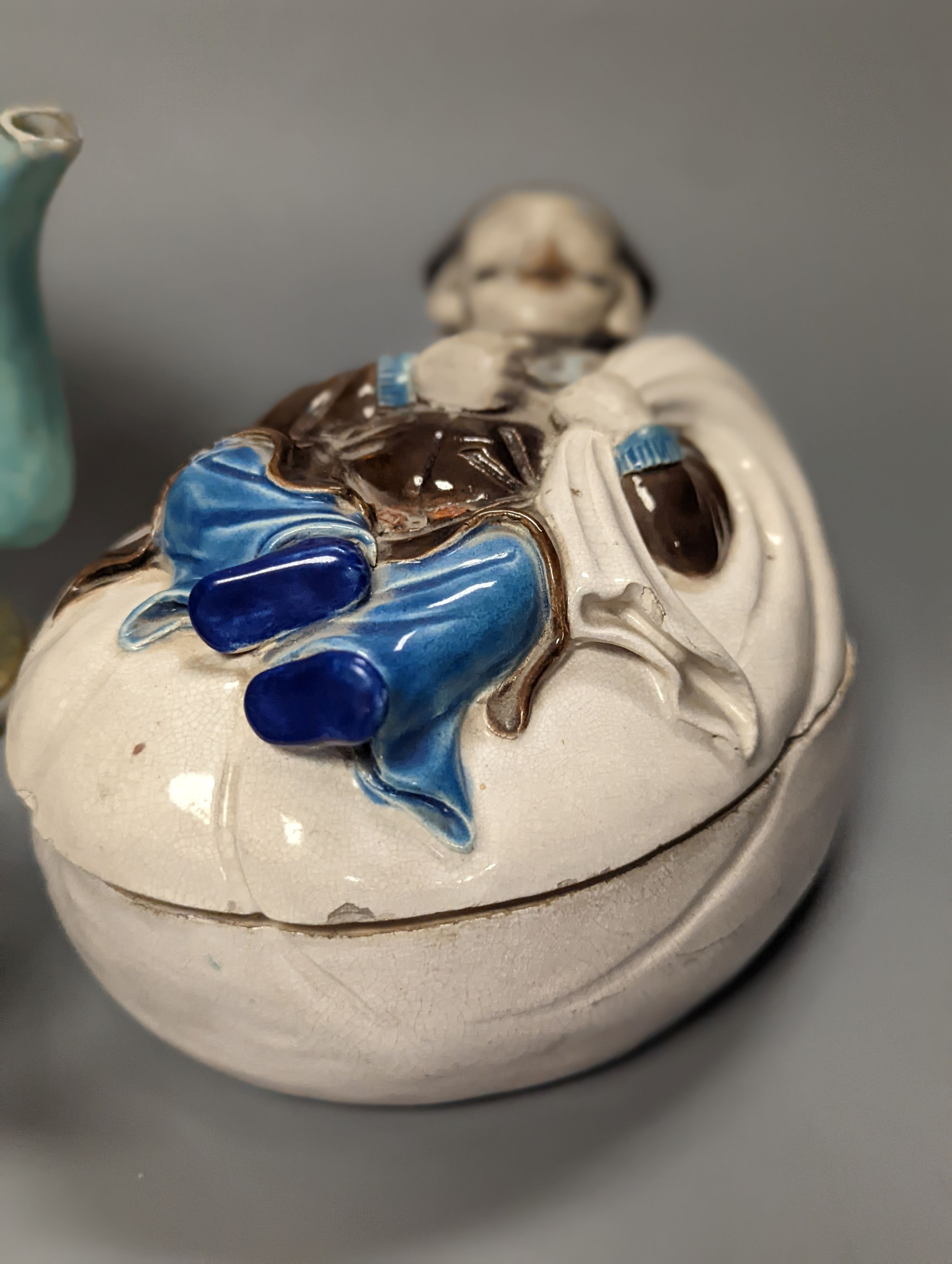 A 19th century Cadogan shape Chinese wine ewer, a Chinese blanc de chine figure riding an ox, an 18th century Chinese miniature blue ground ‘cockerel’ teapot and a Japanese Daikoku figural box and cover. Tallest 19cm